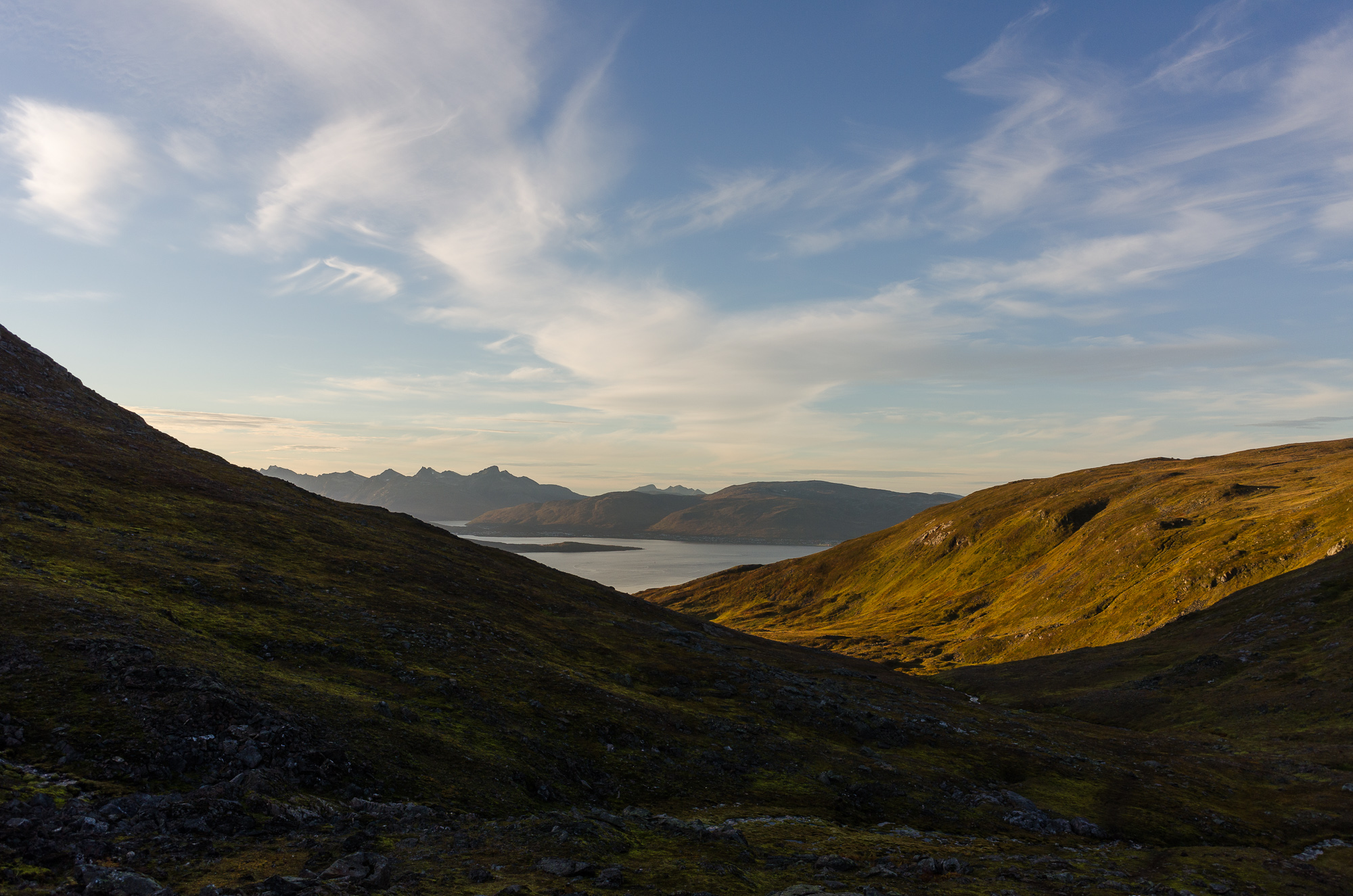 Looking out of the shaded valley towards the sea and Kvaløja in the distance