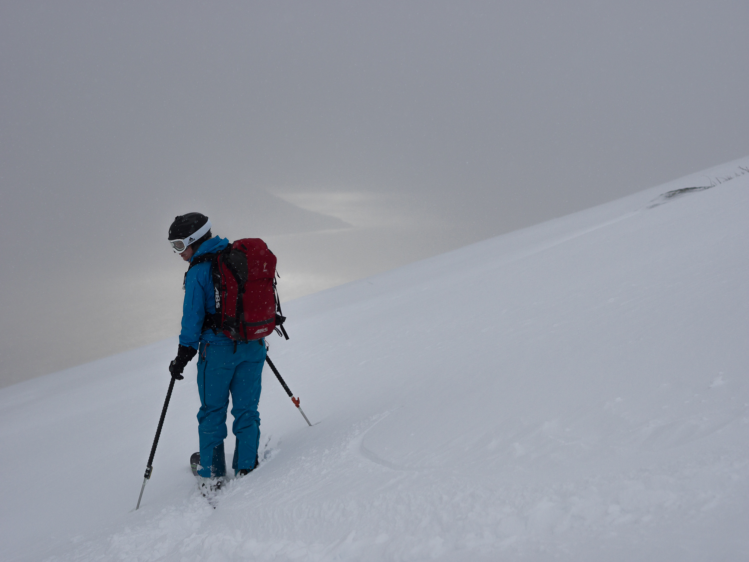 A heavy snow shower right between Linnea and the fjord that glitters in the sun way down there.